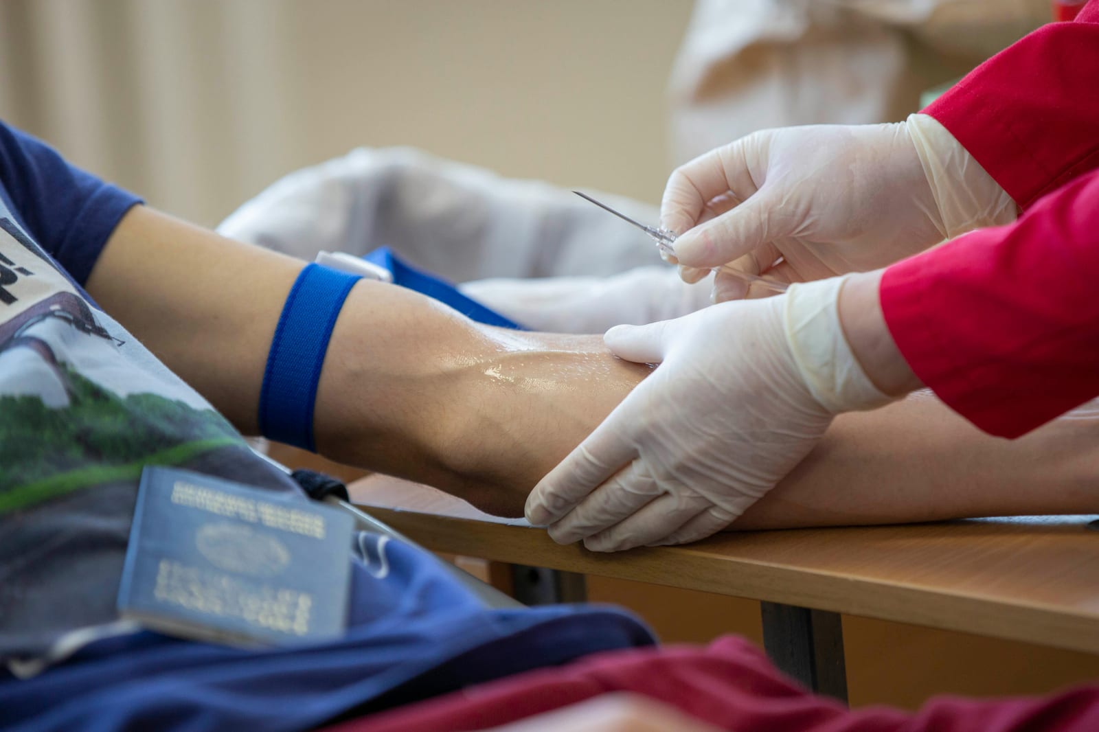 Zdravotník odebírá pacientovi krev z paže