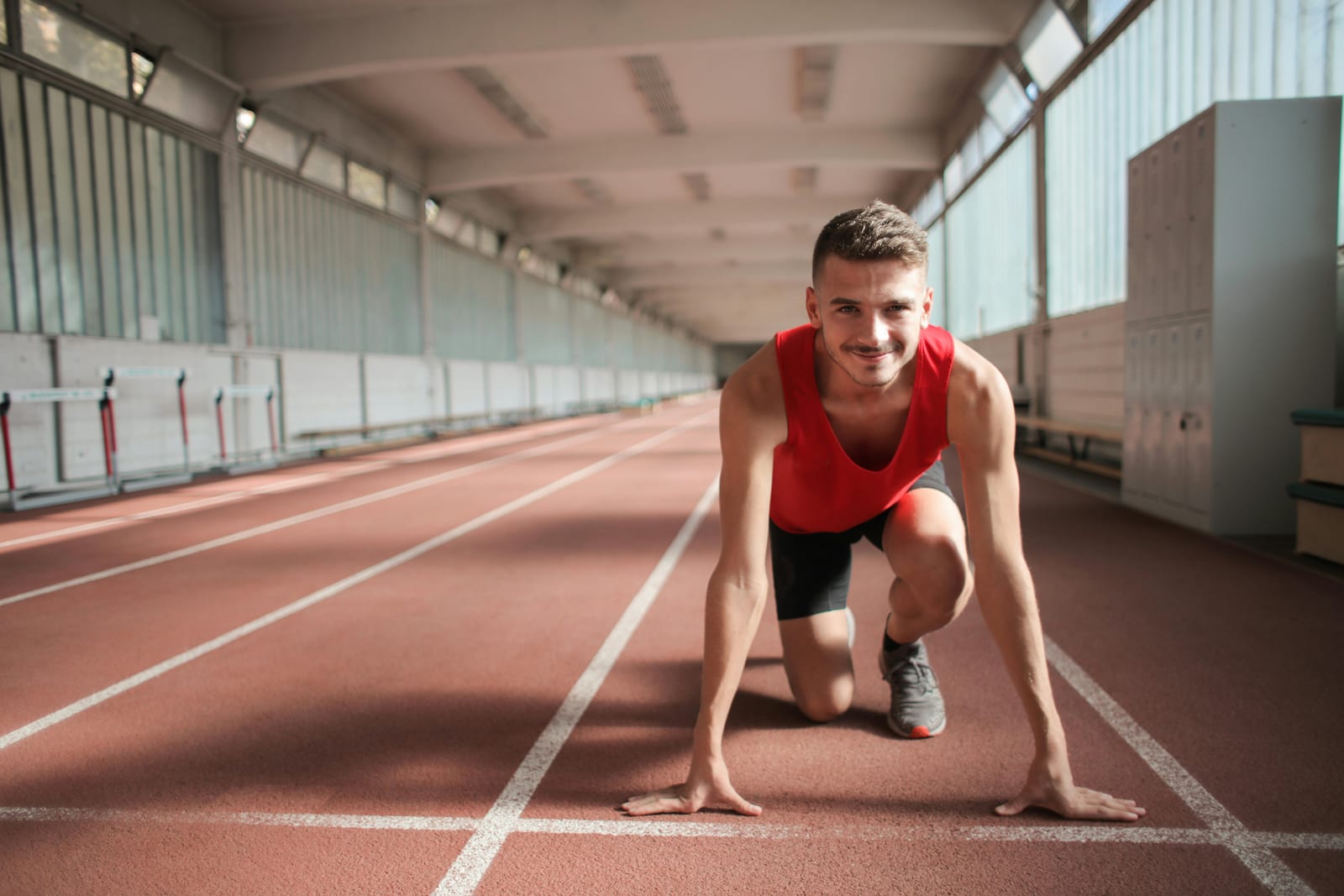 Sprinter připravený ve startovních blocích na dráze