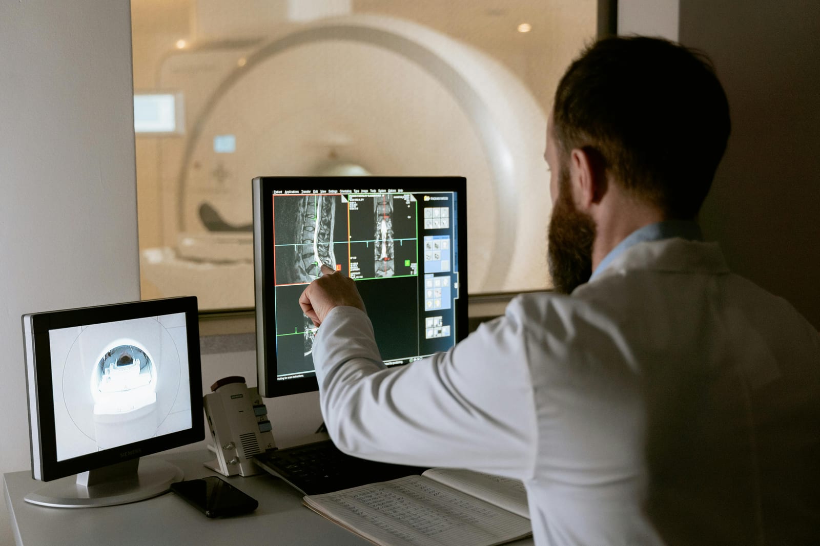 Lékař u monitoru prohlíží snímky z počítačového tomografu