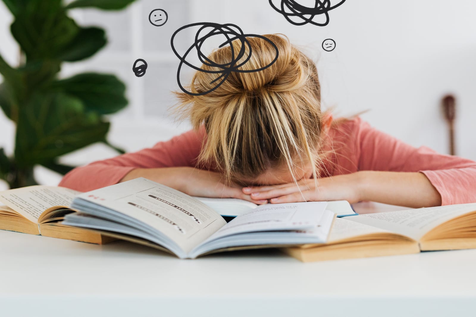 Žena s hlavou položenou na knihách, vyčerpání ze studia, únava