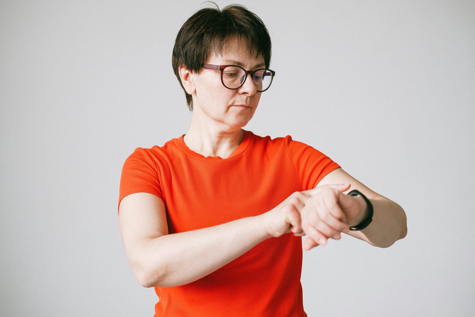 Žena se dívá na hodinky a sleduje čas