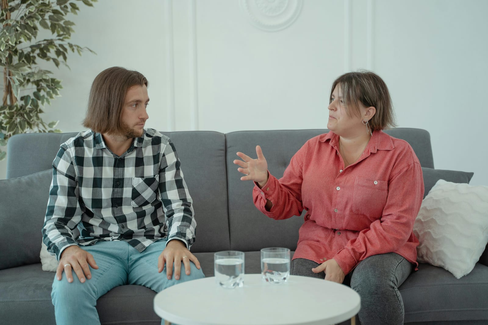 Dvě ženy si na pohovce povídají a gestikulují