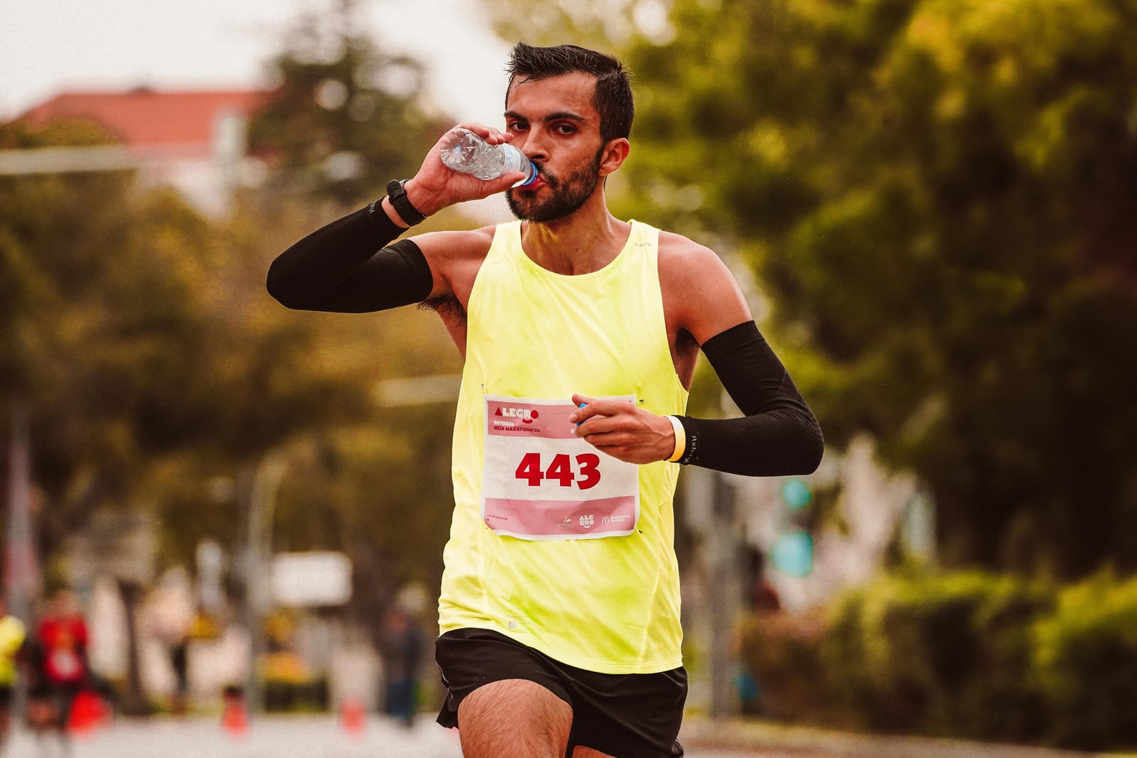 Běžci v městské maratonské závodě pijí vodu