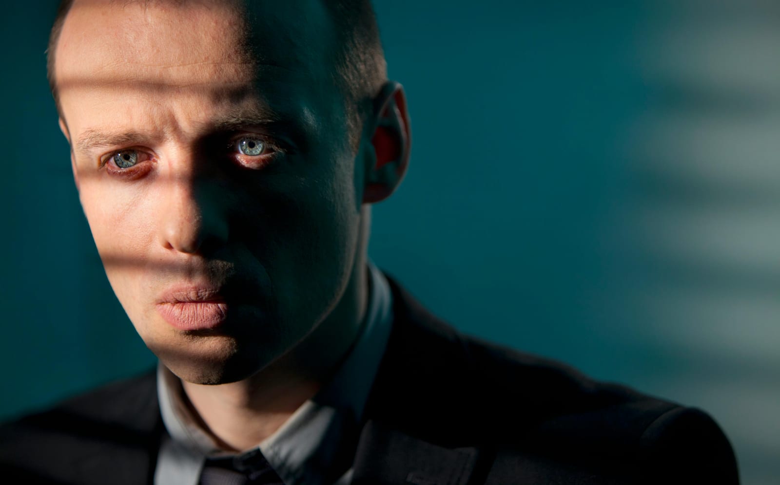 Muž s dramatickým stínem přes tvář