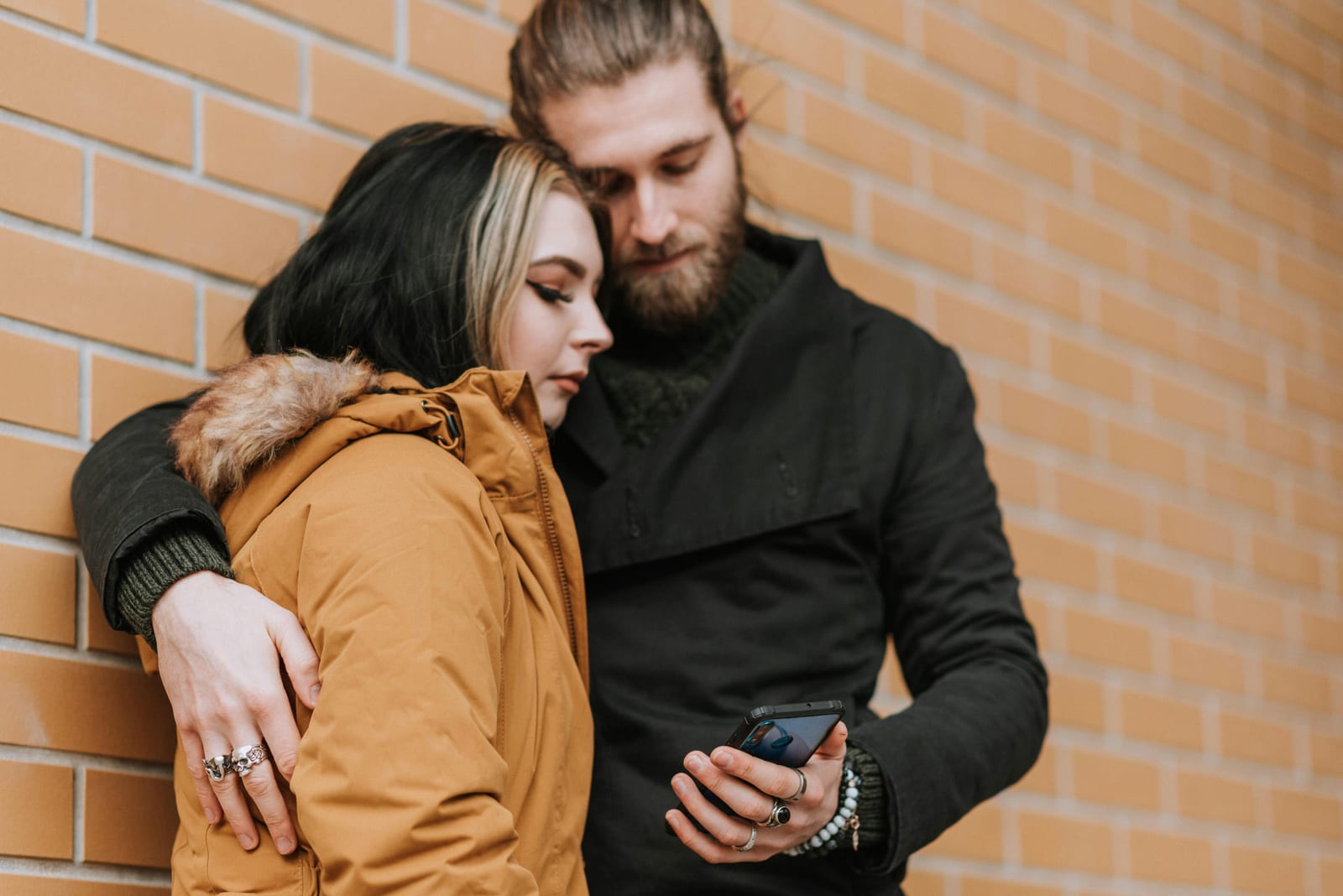 Žena hledí nedůvěřivě stranou, partner stojí za ní
